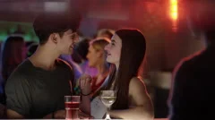 attractive girl flirting with guy at bar in club