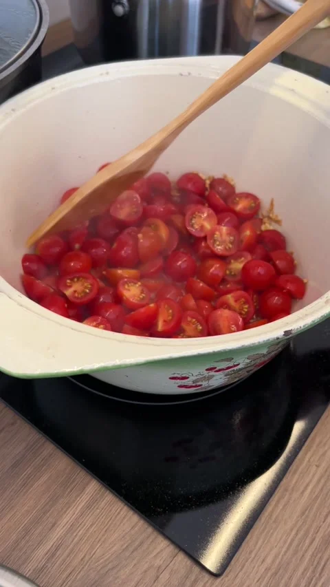 06.19.2022, the chef teaches how to cook cherry tomatoes for sauce in a saucepan 動画素材 331068280