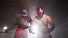 Two masked wrestlers intimidating opponent