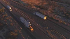 AERIAL: Flying above container semi truck transporting goods on busy highway