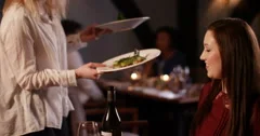 4K Happy couple in a restaurant raise glasses for a toast when food is served