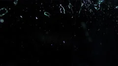 Glass shards on black, breaking over the camera in slow motion