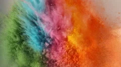 Rainbow holi powder bounces off white canvas in shockwave pattern, slow motion