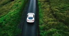 Aerial view electric car driving on country road