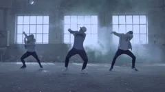 Young group dancing in an abandoned building with smoke.