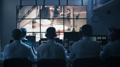 Group of People in Mission Control Center filled with Displays