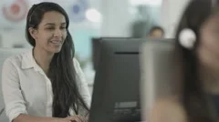 4K Friendly customer service operator talking to customer in busy call centre