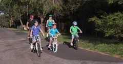 4K Healthy happy family riding bikes in residential area