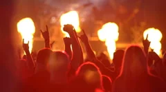 A huge crowd at a rock concert. Fans waving their hands. Slow motion.