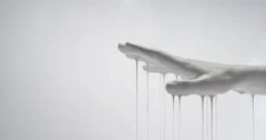White Paint covered hand dripping in slow motion