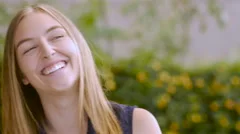Portrait of a pretty blond girl smiling and laughing at the camera