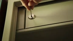 Key unlocked a safe latch and opening door safety deposit box. man folds