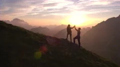 Aerial - Flyover hiking couple celebrating successful climb on the mountain