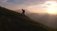 Aerial - Epic shot of a man hiking on the edge of the mountain