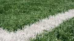 Close up of the out of bounds line on a turf football field