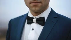 A close-up outdoor shot of elegant man wearing a tux and bow-tie
