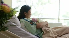 Mother holding newborn baby gesturing for family to enter