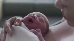 Close Up of Newborn Baby Dreaming on Mothers Chest in Hospital Delivery Room.