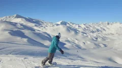 Snowboarder girl riding fresh powder snow off piste in mountain ski resort