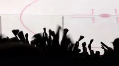 Silhouettes of fans in the background ice hockey rink.
