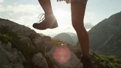 CLOSE UP: Detail of leather mountain shoes and woman climbing steep mountaintop
