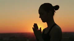 Sporty woman practicing yoga in the park at sunset, making hand greeting namaste