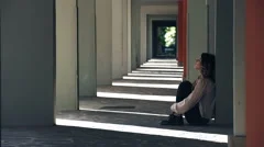 sad depressed woman sitting lonely at the ground of a building 