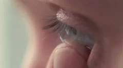 Young handsome man putting contact lens in her eye close up