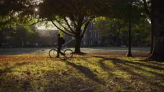 College student on campus walking with bicycle