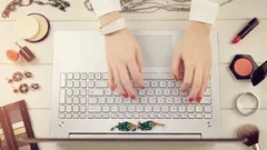 fashion blogger concept - woman with red polished nails working on laptop