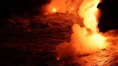 Lava rocks red glowing carried by ocean waves during Big Island volcano eruption