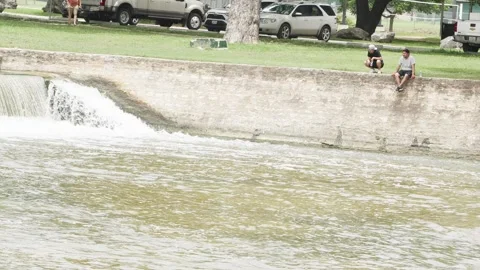 07-June-2026 Georgetown, TX - Man fishing from shore of river in public park Stock Footage 336868069