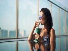 Lady drinking cocktail in pool
