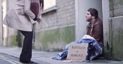 4k, A social worker talking to a homeless man sitting outside in cold