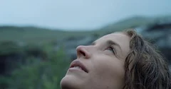 Close up portrait of Woman looking up at rain in nature with wet hair  Hiker