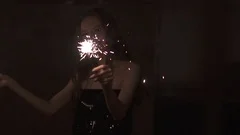 sexy young girl having fun and dancing with sparklers at the party