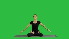 Woman practicing yoga in lotus pose with namaste hands gesture on a Green Screen
