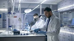 In a Modern Laboratory Two Scientists Conduct Experiments. 