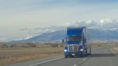 CLOSE UP Freight semi truck speeding along the Great Plains highway on sunny day