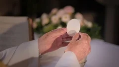 Priest's hands breaking the wafer