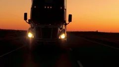 CLOSE UP: Freight container semi truck driving along the country highway at dusk