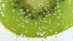 Carbonated Soda Into Glass With Slice Of Kiwi Closeup Bubbles Focus
