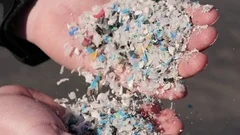 Man Shows Recycled Plastic Pieces In His Hands