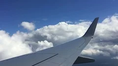 Wing of plane on blue sky with clouds background. Travel by air on airplane