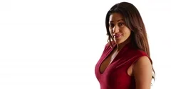 Portrait of sultry Latina female laughing at camera flirtatiously in studio