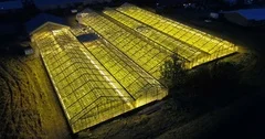 Beautiful aerial view of the large greenhouse with light in it. Ecological farm