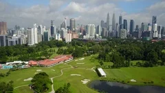 Aerial drone shot flying over golf course towards Kuala Lumpur skyline
