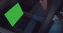 GREEN SCREEN Business lady rides in a car, using her portable laptop computer