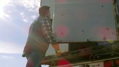 Truck Driver Closes Doors of His  Truck Cargo Trailer. Professional Driver.