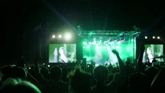 fans jump and dance at concert, excited audience waving hands at rock festival